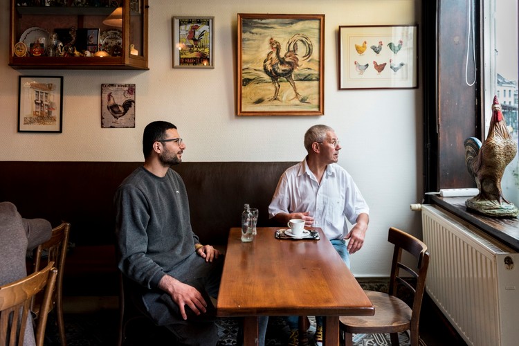 Jan en Mamoun zitten aan tafel in café De Hanekeef